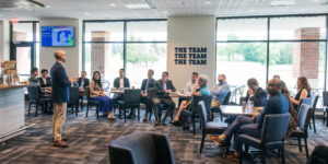 man speaking to individuals at event
