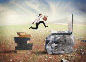 Concept of technology migration with businessman jumping from book to laptop
