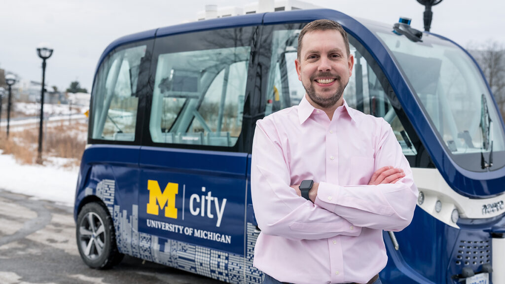 Greg McGuire standing in front of Mcity vehicle