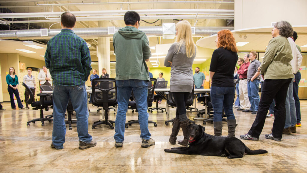 project management attendees standing with dog