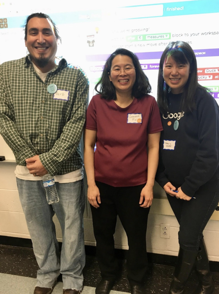 three individuals smiling at 'Hour of Code' event