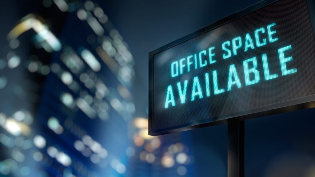 office space available sign with lit up buildings behind