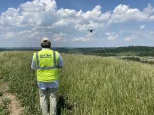 Image of a Sniffer Robotics employee using a drone to detect methane at ground surfaces.